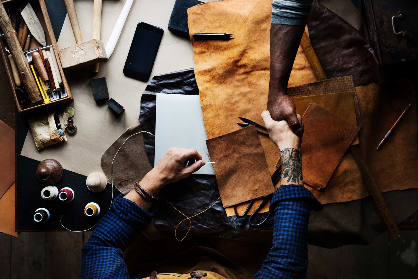 aerial-of-learther-craftsmen-shaking-hands
