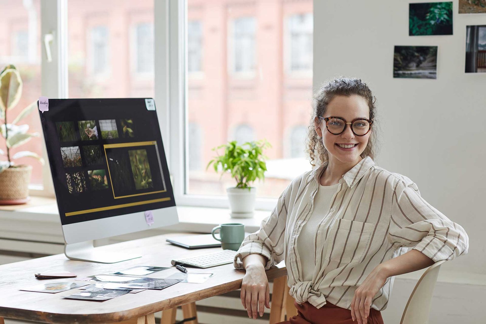 smiling-female-photographer-posing-at-desk